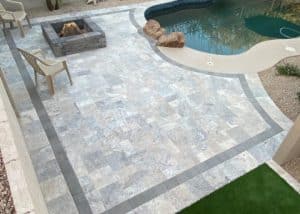 Tiled patio with dark border surrounding fire pit and pool deck in Richmond VA