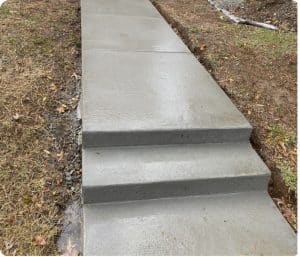 Smooth gray concrete walkway with two steps and dirt-grass surroundings in Richmond VA
