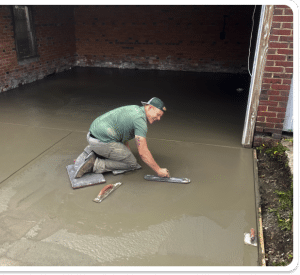 Freshly poured concrete garage floor being troweled by a contractor in Richmond VA
