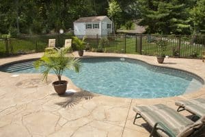 Stamped concrete pool deck with flagstone pattern and compass rose inlay in Richmond VA