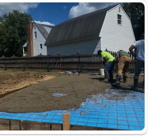 Freshly poured concrete slab with wire mesh reinforcement and blue vapor barrier in Chesterfield VA