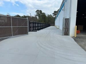 Grey broom-finished concrete slab with expansion joints next to an industrial building in Richmond VA