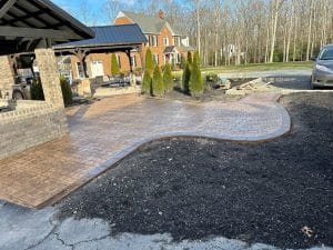 Stamped concrete pathway with cobblestone pattern and dark border leading to patio area in Midlothian VA