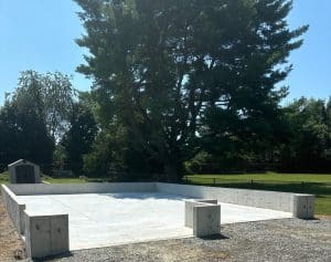 Concrete foundation with walls for a structure, surrounded by gravel and trees in Richmond VA