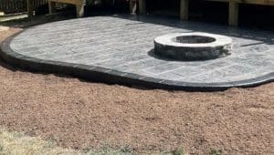 Stamped concrete patio with square pattern, dark border, and built-in fire pit in Norfolk VA