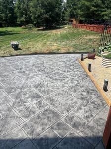 Ashlar slate stamped concrete patio with gray tones next to a gravel path and garden in Virginia Beach VA