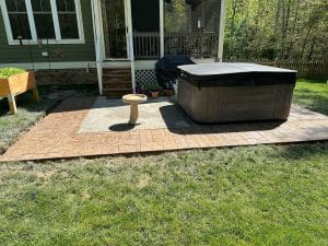 Stamped concrete patio and walkway with brown cobblestone pattern surrounding a hot tub in Hopewell VA