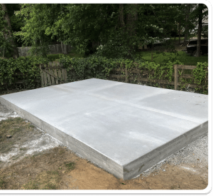 Smooth-finished concrete slab with expansion joints, forming a foundation in a backyard in Chesterfield VA