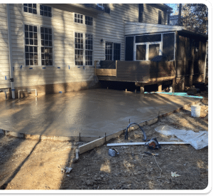 Freshly poured concrete patio with smooth finish, adjacent to a wooden deck in Chesterfield VA