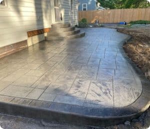 Worn broom-finished concrete steps leading to damaged flagstone-like walkway in Richmond VA