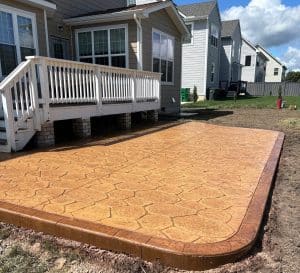 Brown stamped concrete patio with irregular flagstone pattern and dark border in Richmond VA