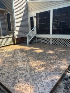Stamped concrete patio with ashlar pattern in muted tones next to house entry steps in Midlothian VA