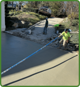 Newly poured broom-finished concrete driveway under construction by crew, with smooth finish in Richmond VA